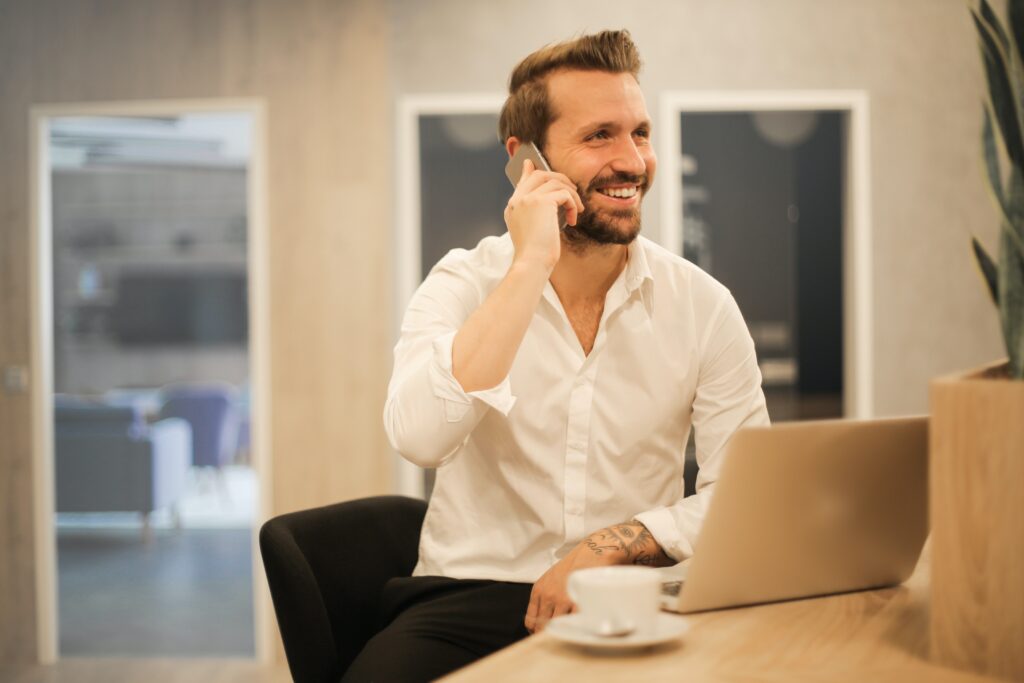 A man in a white shirt talking on a cell phone