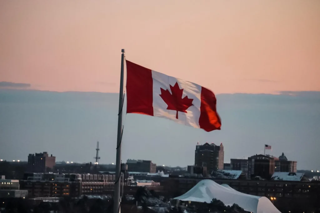 A Canadian flag with a small USA flag behind it