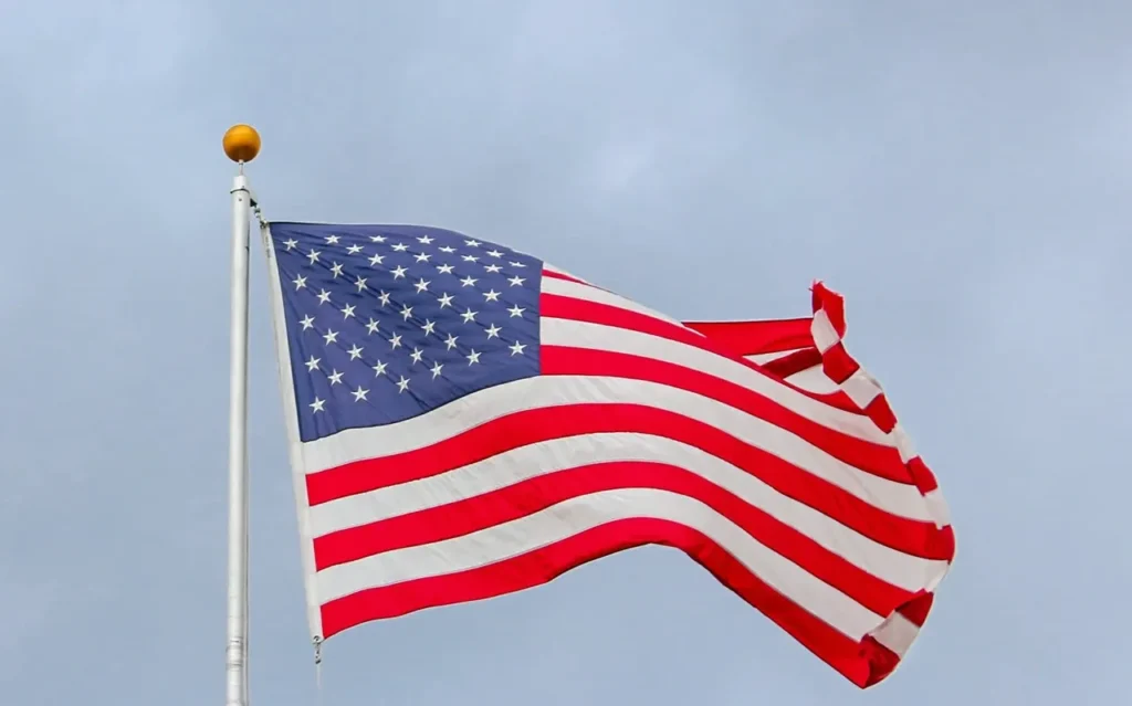 The United States of America Flag waving against a blue gray sky