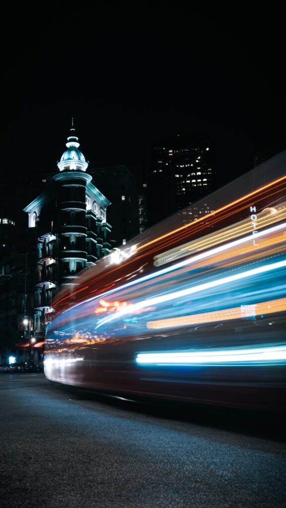 A blurry image of a bus in a city at night