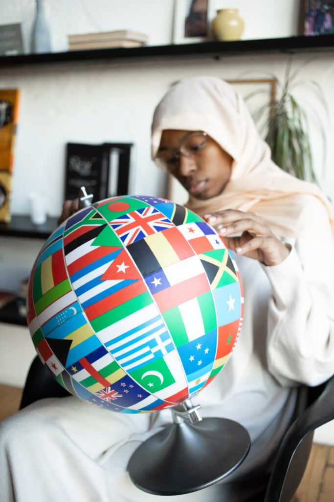 A woman looking at a globe made of flags