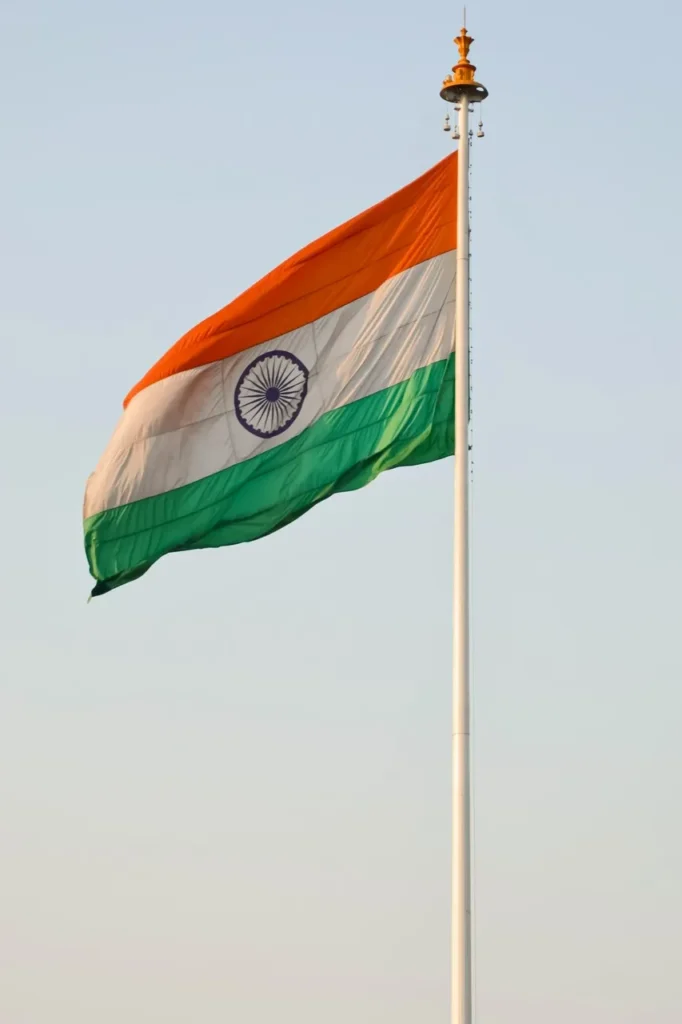 The Indian flag waving against a pale blue sky