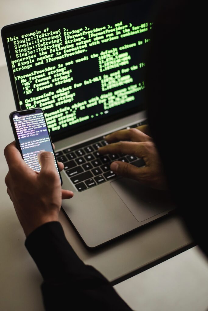 A person using a phone and a laptop